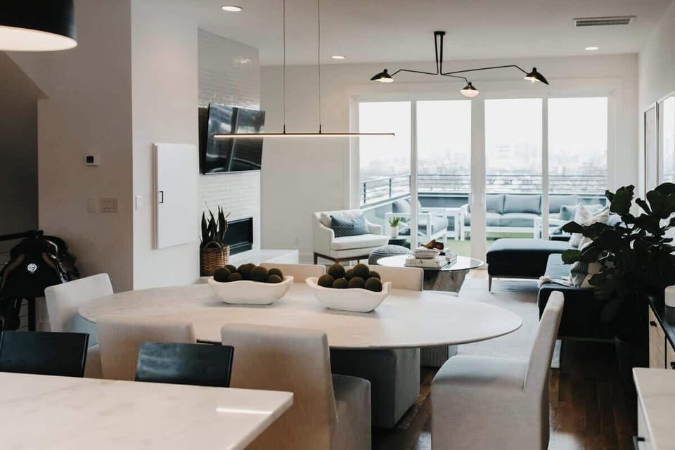 Spacious living and dining room with Restoration Hardware dining table, chairs, and sofa.