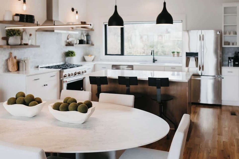 Spacious living and dining room with Restoration Hardware dining table, chairs, and sofa.