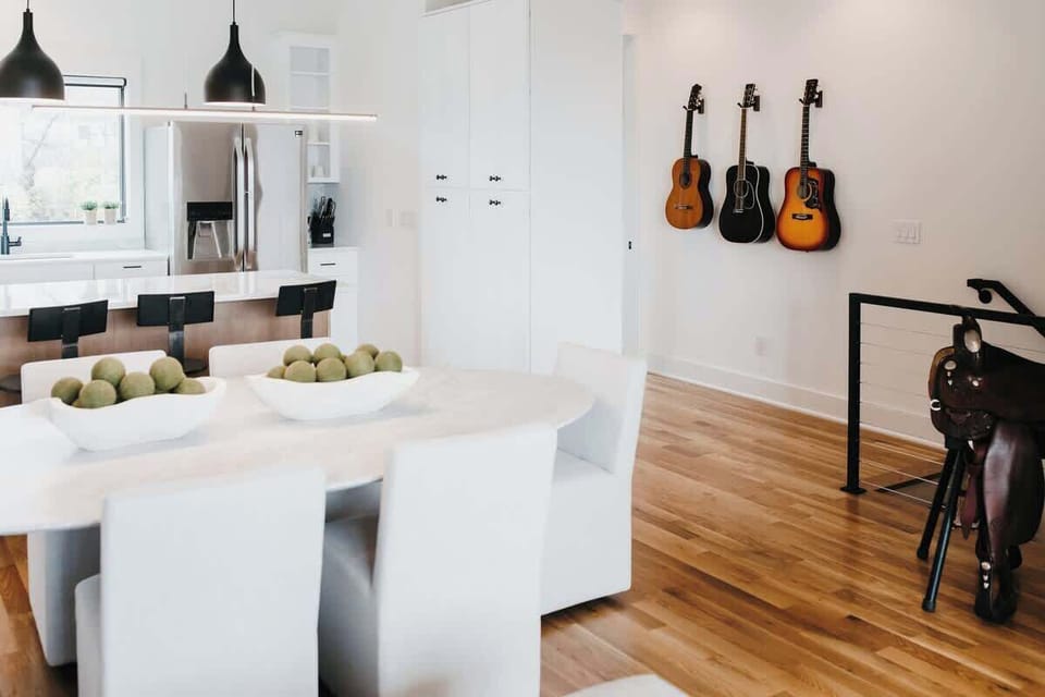 Spacious living and dining room with Restoration Hardware dining table, chairs, and sofa.