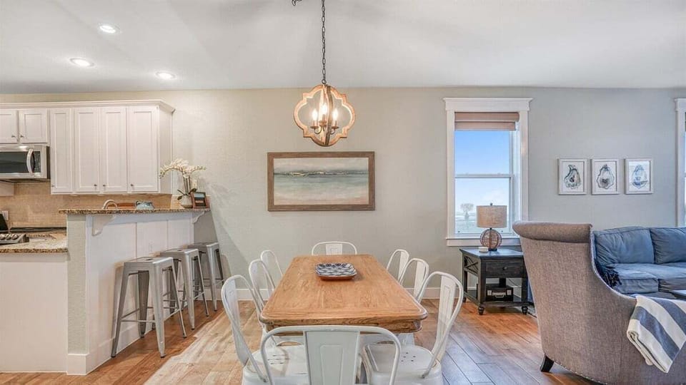 Coastal dining area with elegant chandelier and seating for family meals