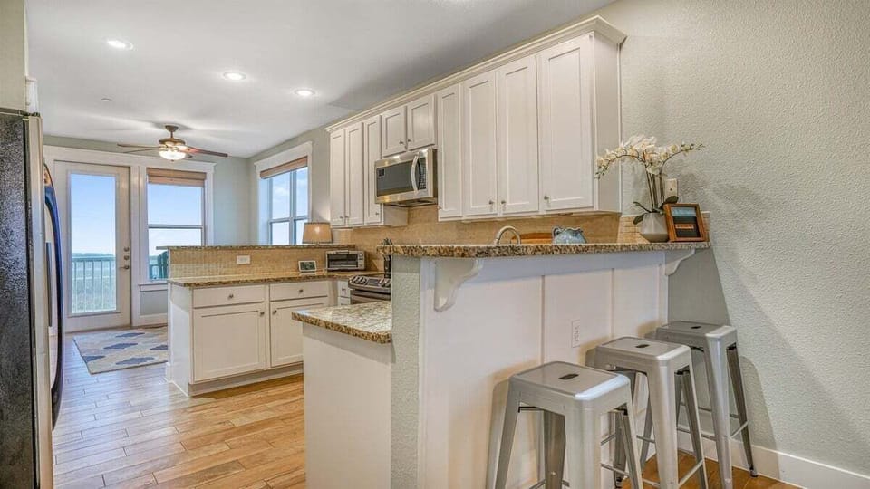 Fully stocked kitchen with granite countertops and bar stools