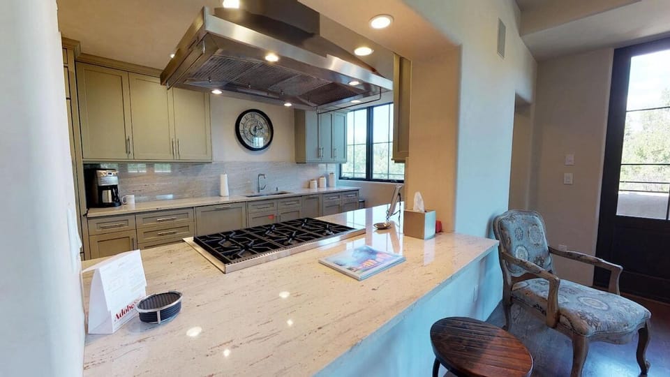 Bar sitting area with two bar stools and view to kitchen