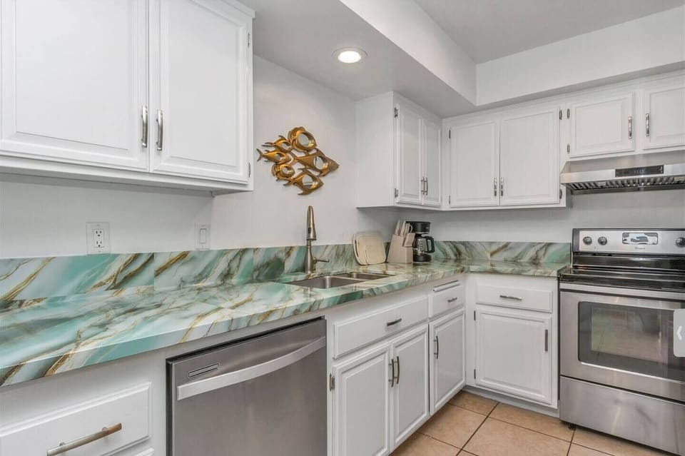 Fully equipped kitchen features all the essentials—including a large refrigerator, stove, microwave, dishwasher, coffee maker, complete cookware and plenty of dishes and glasses—perfect for preparing meals and enjoy it.