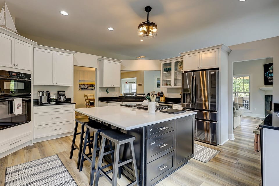 Fully equipped kitchen with stainless steel appliances and 3 barstools for extra seating.
