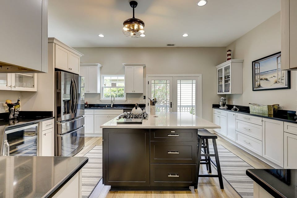 Fully equipped kitchen with stainless steel appliances and 3 barstools for extra seating.