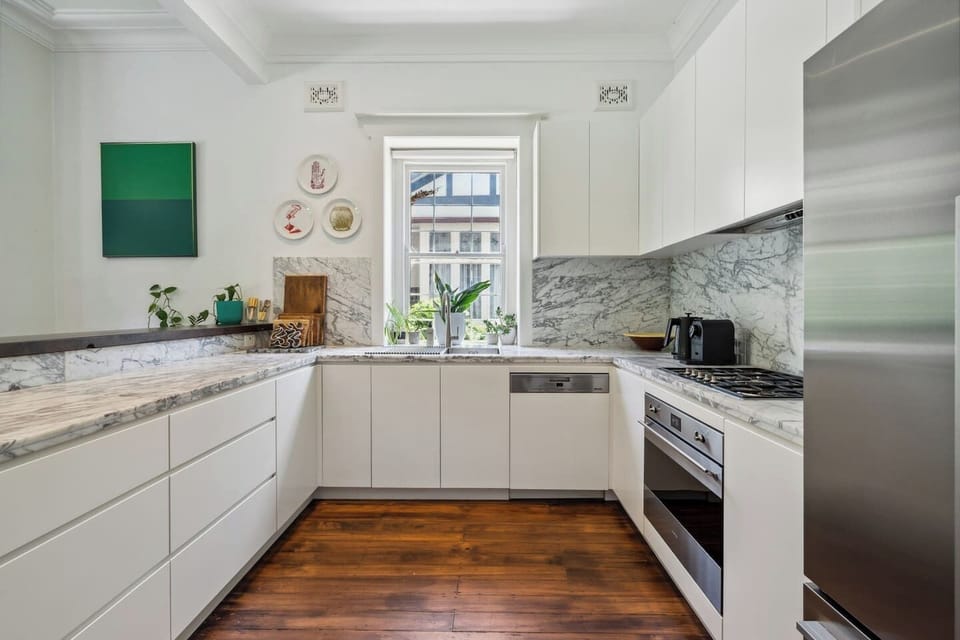 The marble-topped kitchen is both stylish and functional, featuring an oven, dishwasher, and Nespresso machine to elevate your morning routine.