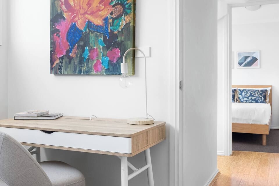 A dedicated workspace with bold artwork and soft lighting provides an inspiring corner for catching up on emails or enjoying quiet moments.