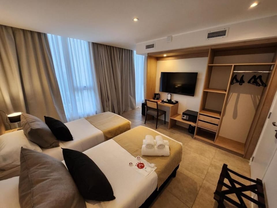 Settle in with smart TV, workspace, and open wardrobe.