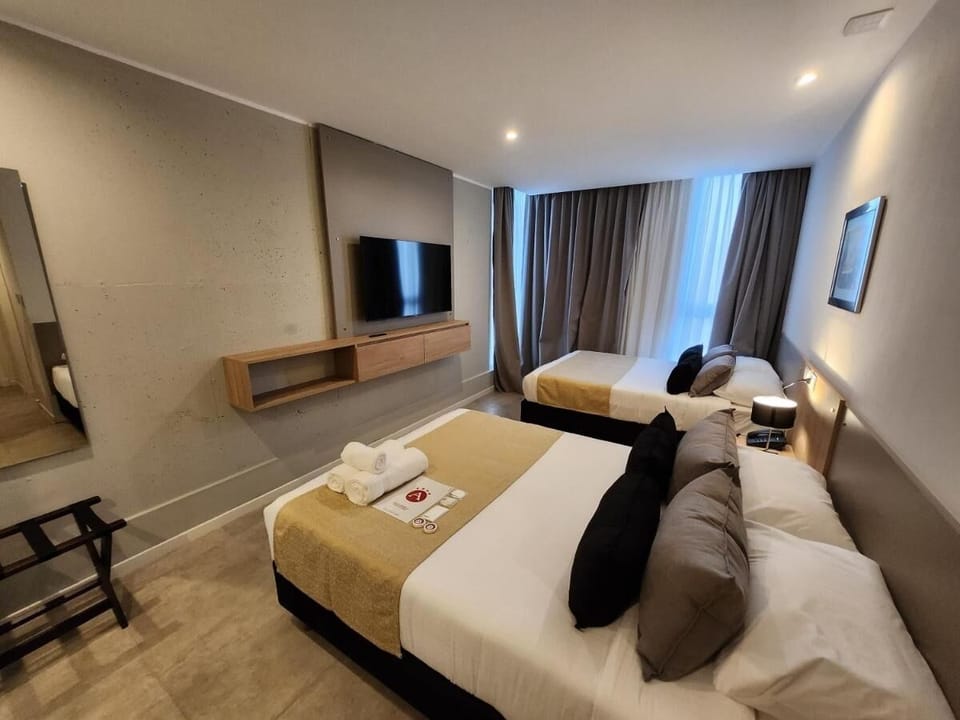 Unwind on crisp twin beds in a bright, modern room.