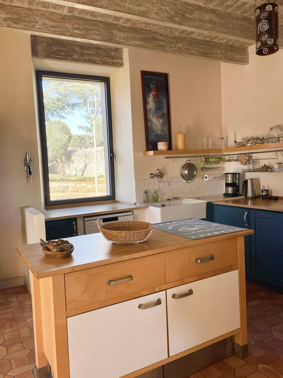 Warm, functional kitchen with exposed beams, large central island and natural light. Unobstructed view of the outside, so you can cook in peace and quiet in an authentic setting.