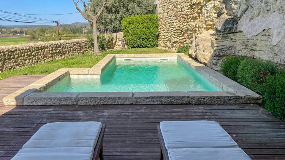 This light-filled private swimming pool, lined with natural stone and surrounded by a wooden terrace, invites you to relax. Deckchairs await you for sunbathing overlooking the fields and hills of Provence.