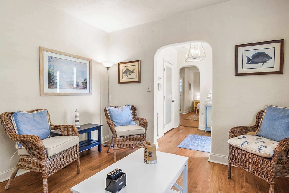 Relax in this charming living room with nautical decor and cozy wicker seating, perfect for unwinding after a day of adventure.
