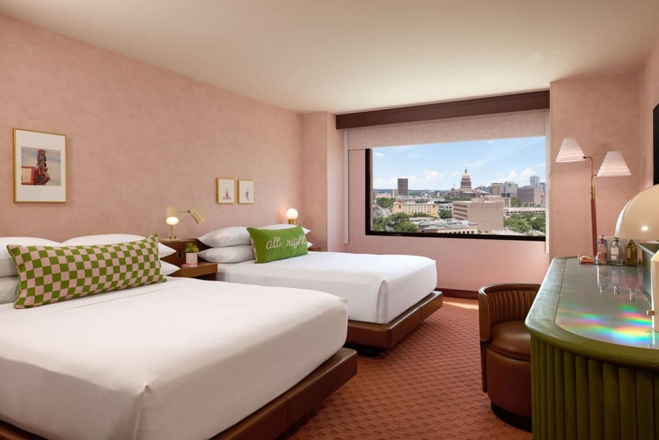 Two queen beds with city view and green desk