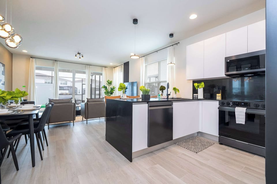 Channel your inner chef in this contemporary kitchen with black countertops, stainless appliances, and task lighting.
