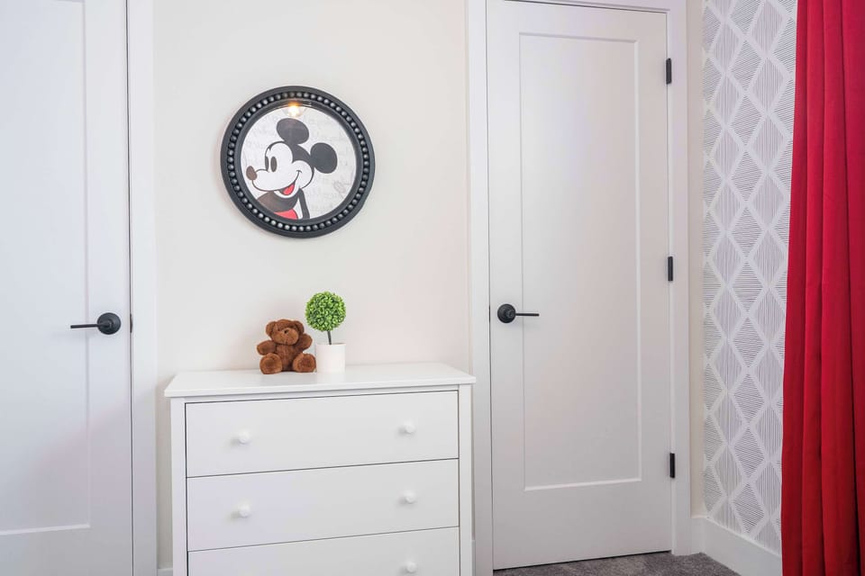 Playful pop-art Mickey mural illuminates this vibrant twin bedroom—fun for Disney fans of all ages.