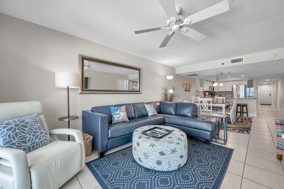 Spacious living & dining area w/ matching armchairs, coastal tones, and an open, airy layout.