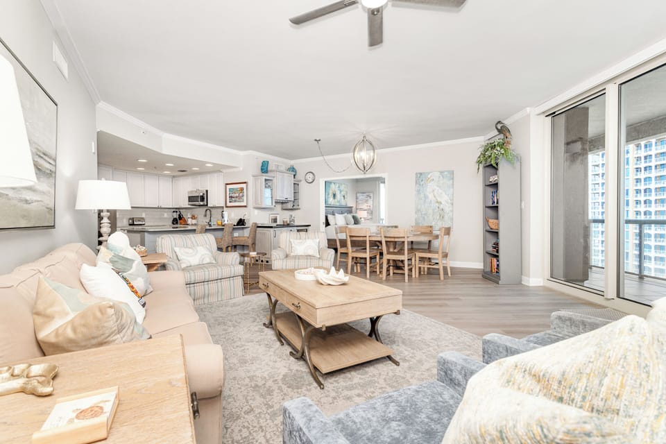 Settle into this bright, open-concept space where coastal-inspired furnishings invite you to unwind. Enjoy seamless flow from living to dining to kitchen, with city views beyond your private balcony.