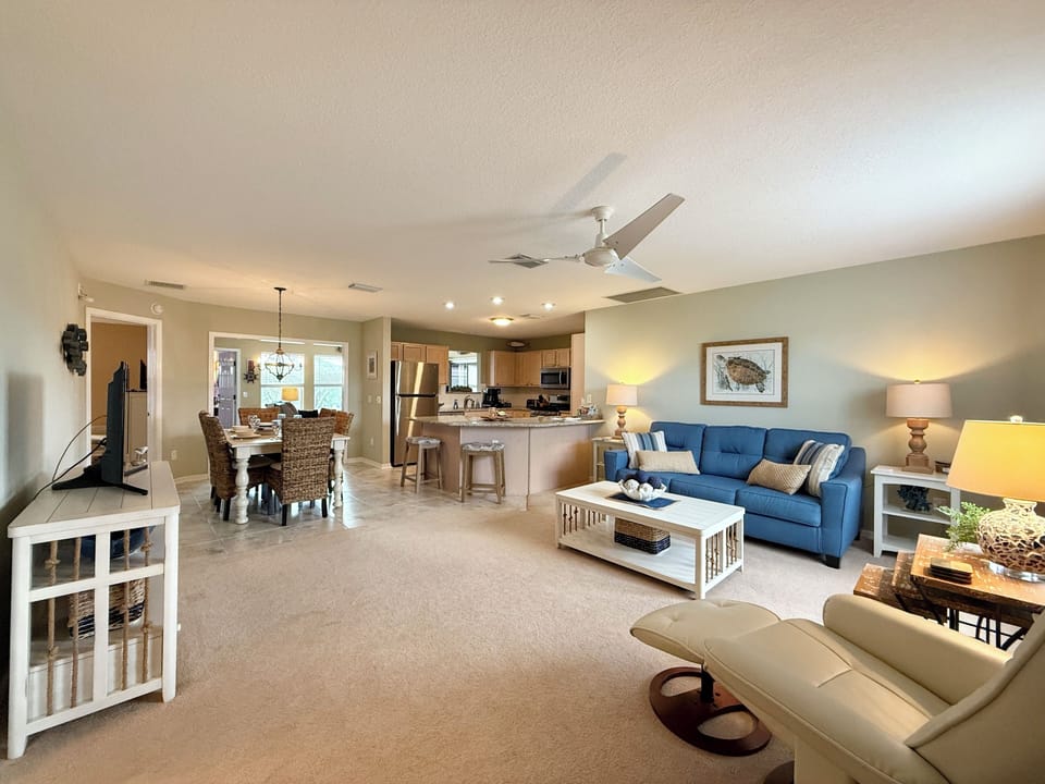 It shows the interior of a cozy, beach-themed open-concept living space.