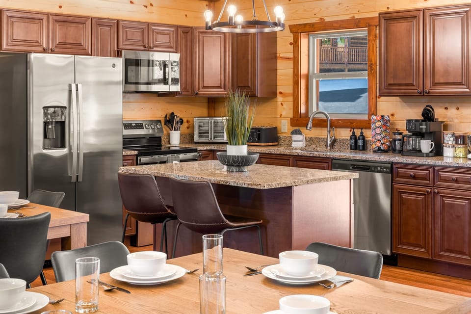 Fully equipped chef’s kitchen with granite countertops and bar seating.