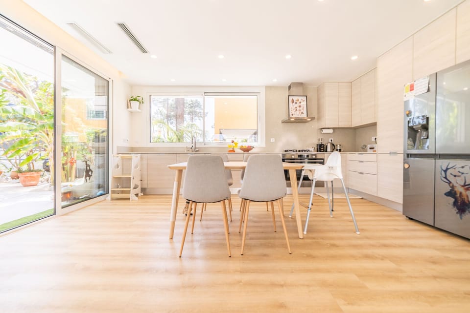 Modern open-plan kitchen and dining area with wooden flooring — Villa Aroeira Village, luxury holiday villa in Aroeira