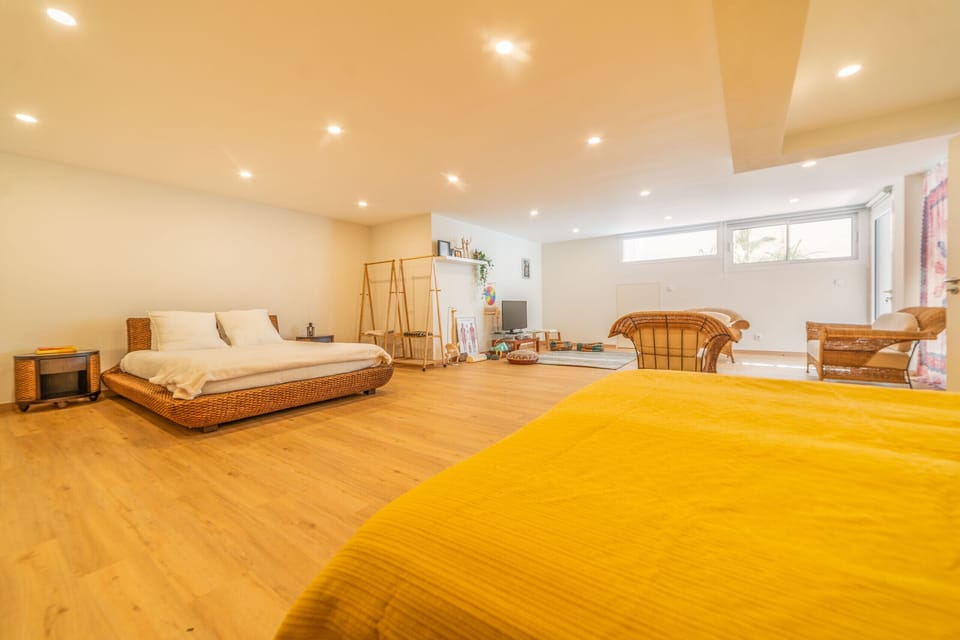 Spacious bedroom with woven bed frame and yellow accent — Villa Aroeira Village, holiday villa in Aroeira