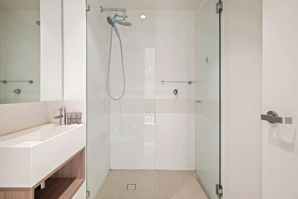Refresh in the full bathroom with a walk-in rain shower, vanity, and essential toiletries.