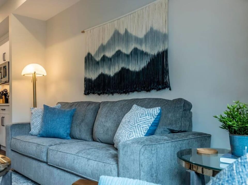 This open-concept living space with a plush sofa and nearby kitchen is ideal for both relaxation and easy living.