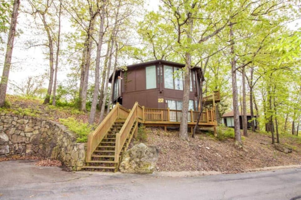 This modern elevated home offers a unique `treetop` living experience, blending seamlessly with the surrounding lush natural landscape. Multiple large windows allow for abundant natural light and scenic views, making this a bright and inviting retreat.