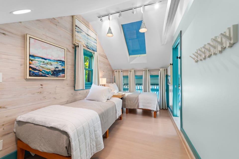 The upstairs 3rd bedroom via the floating staircase with pocket door for privacy, 2 twin beds.