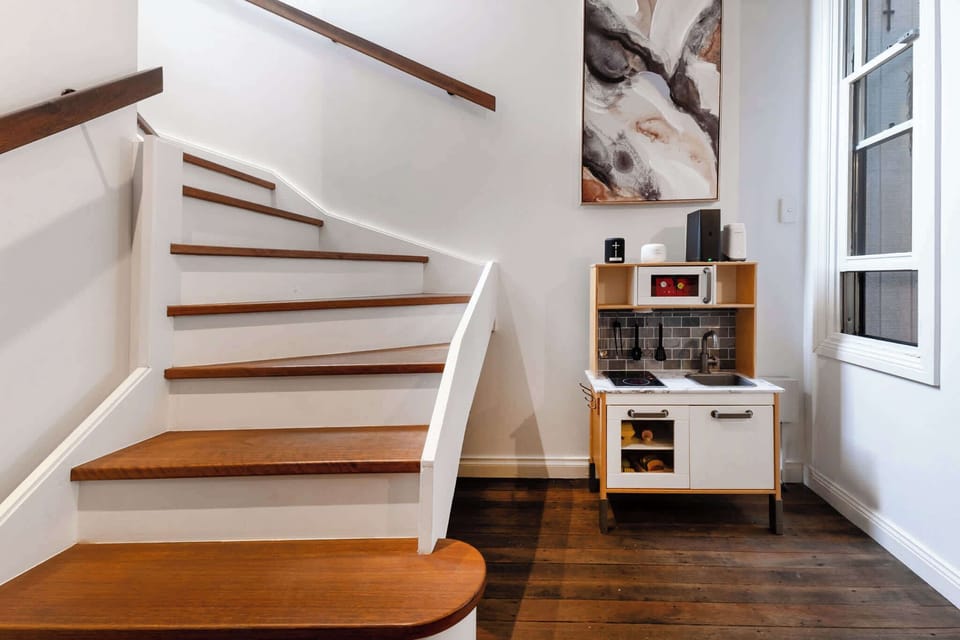 A beautifully designed wooden staircase connects the main level to the first floor, adding warmth and charm to the home’s inviting interior.