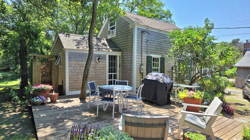 Deck with dining table and chairs, lounge chairs and gas grill