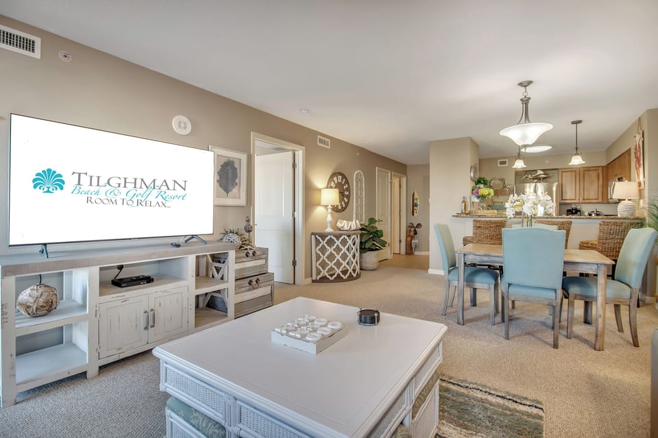 Relax in your spacious open-plan living area featuring coastal-inspired décor and a fully equipped kitchen for memorable vacation meals.
