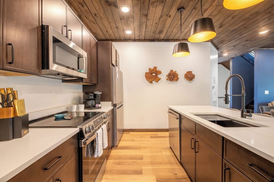 Your private chef's kitchen awaits, featuring sleek stainless appliances, warm wood details, and stylish pendant lighting to inspire memorable meals together.