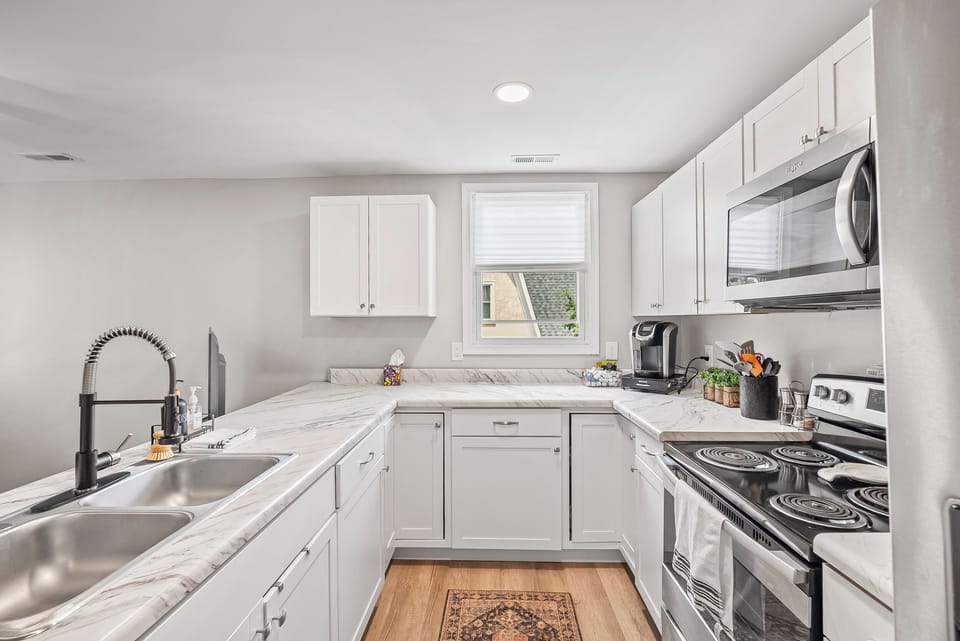 Full kitchen stocked with dishes, glasses, silverware, and cooking dishes