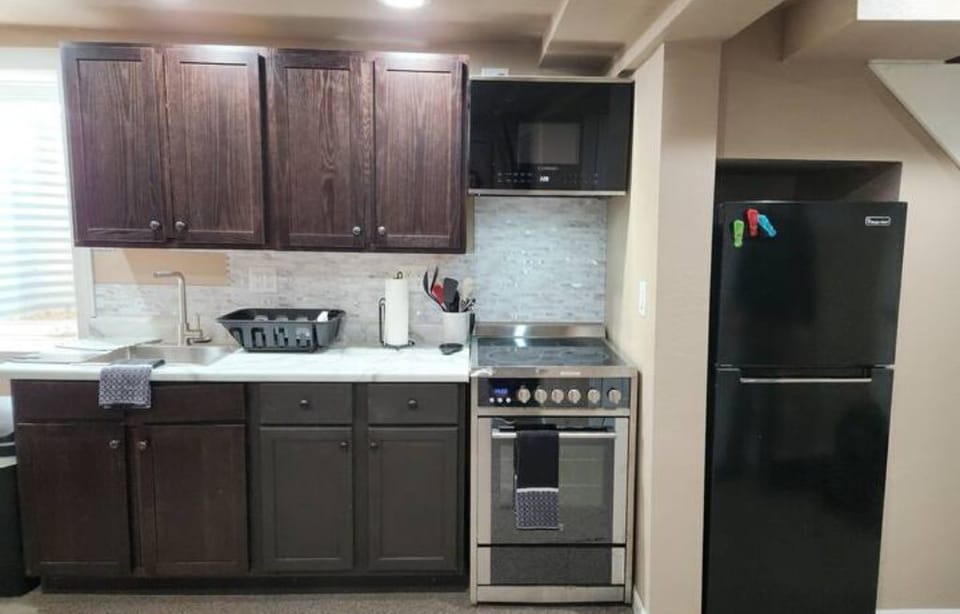 Full kitchen includes stove, microwave, fridge, towels, and dishes