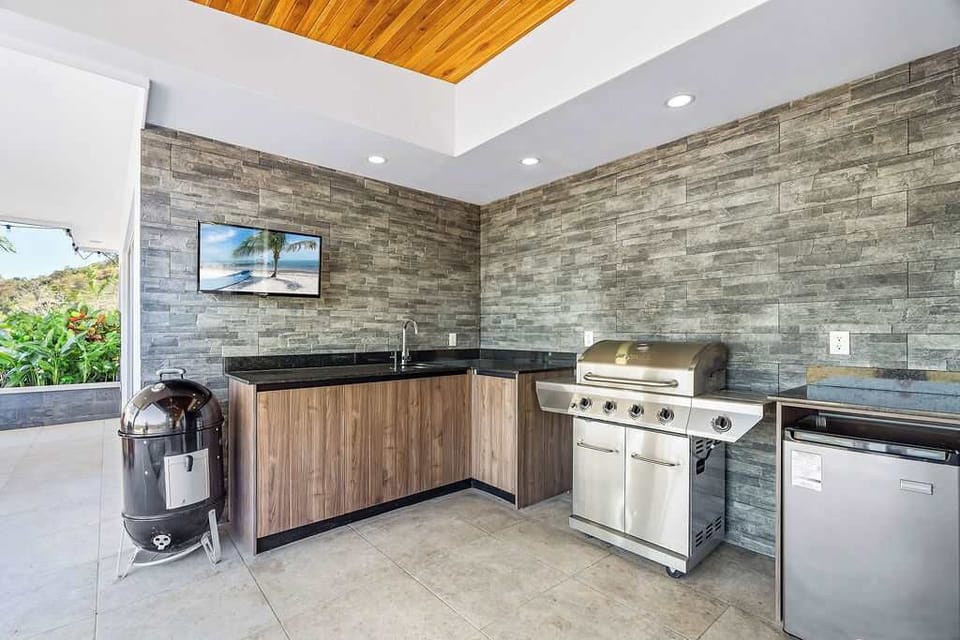Outdoor Kitchen with BBQ Grill: Sip, and soak in the sun's warm embrace.

