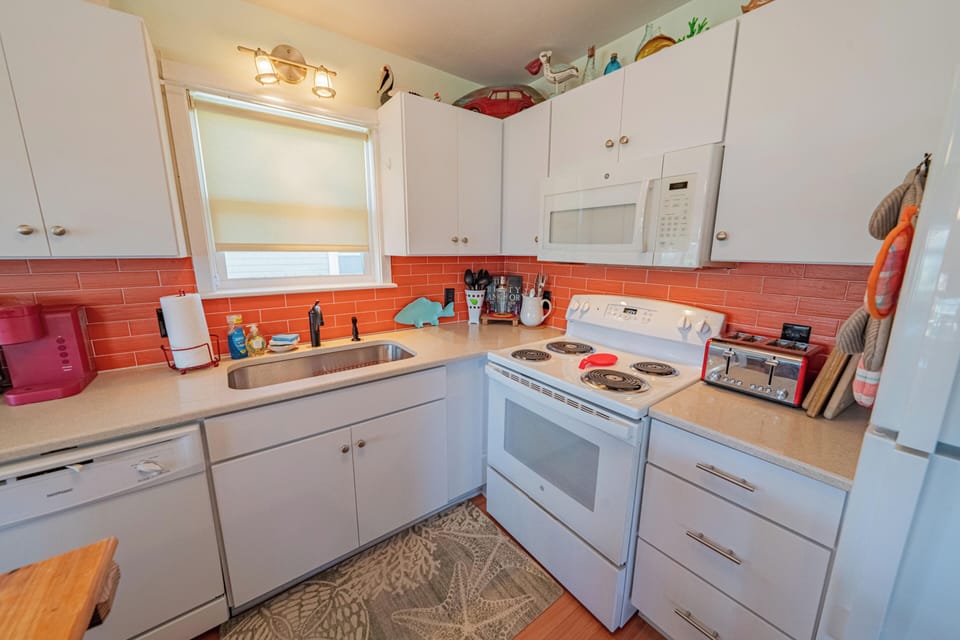 Bright, cheerful kitchen with full appliances and colorful backsplash