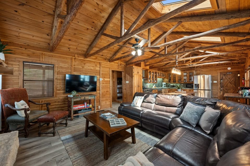 Gather in the spacious living room featuring a large sectional, Smart TV, and sweeping views of Lake Travis. It’s the perfect place to unwind after a day of adventure—whether you're watching a movie or just enjoying the view with family and friends.