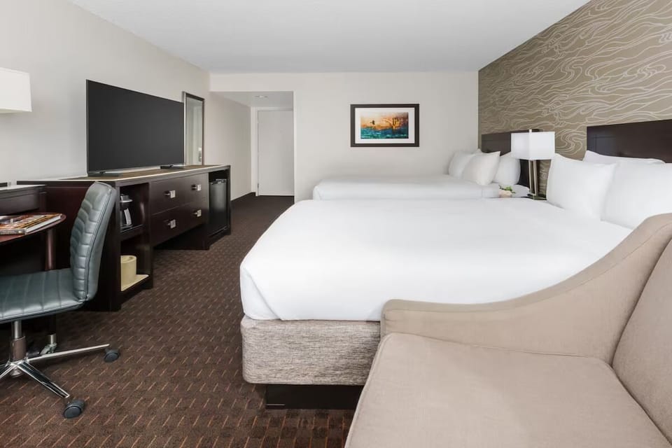 Unwind in a spacious double-queen room with sleek workspace.