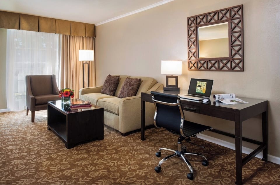 Catch up on emails at the dedicated desk beside comfy seating.