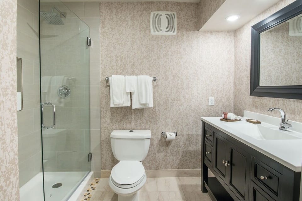 Refresh in the spacious bath with a glass shower enclosure.