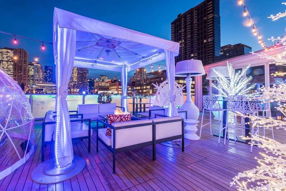 Lounge under twinkling lights with a breezy skyline backdrop.