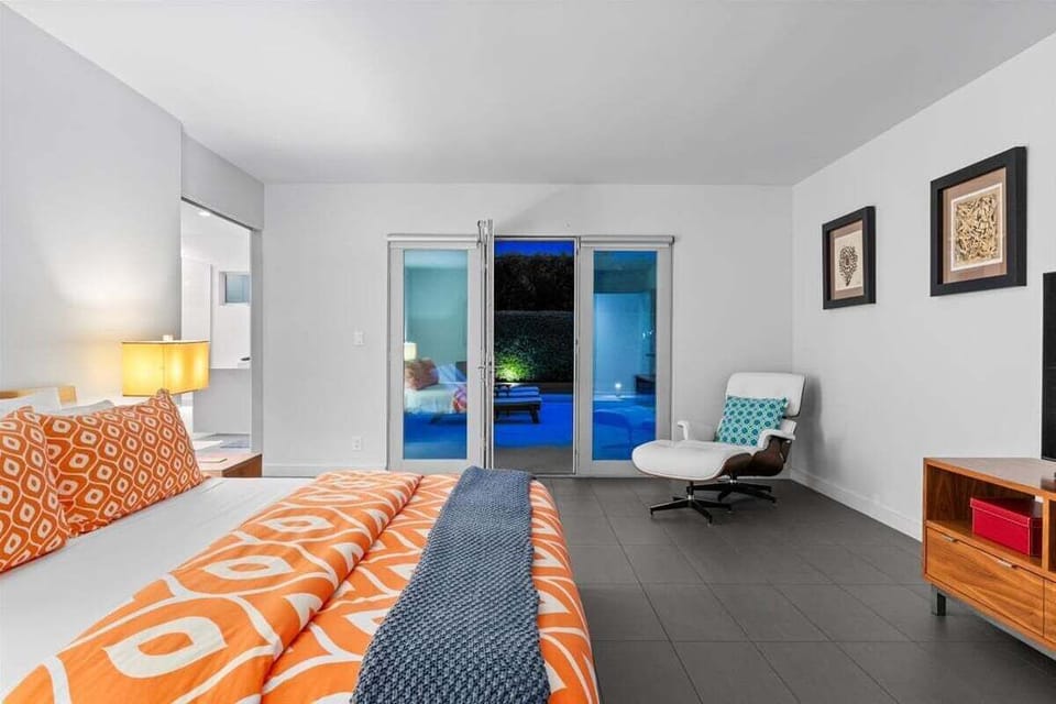 Spacious primary suite with nighttime pool views