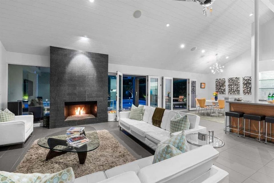 Dramatic living room with fireplace and indoor-outdoor flow at night