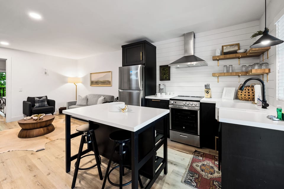 Stylish kitchen with breakfast bar and stainless steel appliances. (Suite A)