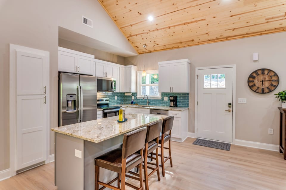 Bright modern kitchen with vaulted wood ceilings and island seating