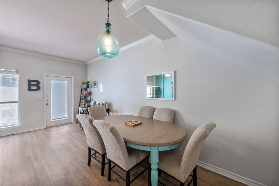 Gather around your spacious dining table for memorable meals under the charming turquoise pendant light.