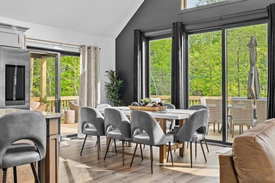 The dining table seats eight with views of the deck and trees beyond.