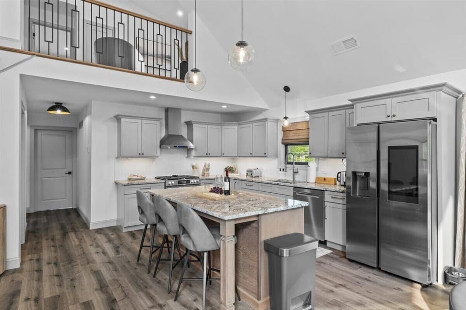 The chef's kitchen features a large island with bar seating and stainless appliances.