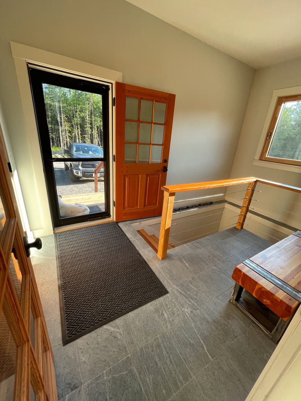 Main Entrance to the mudroom with a bench and coat rack to offload your things!